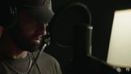 Eminem recording a voiceover for Stans (2025) in a studio booth. (Image via Eminem Music)